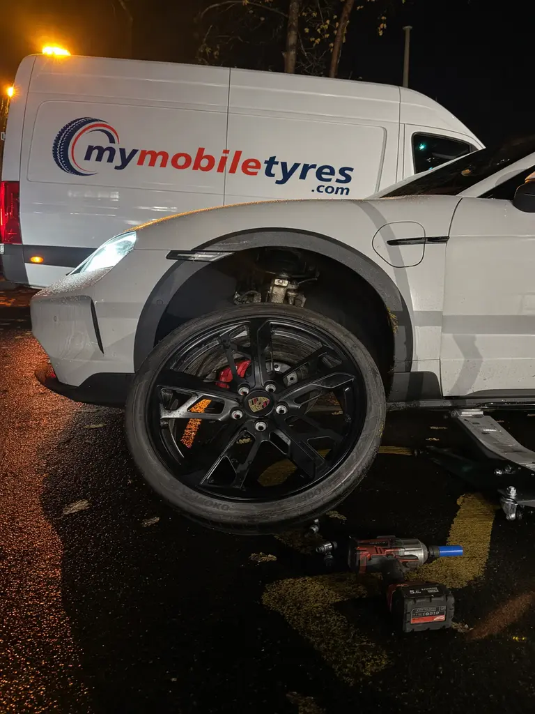 Mobile tyre fitter working on a car tyre in Westminster
